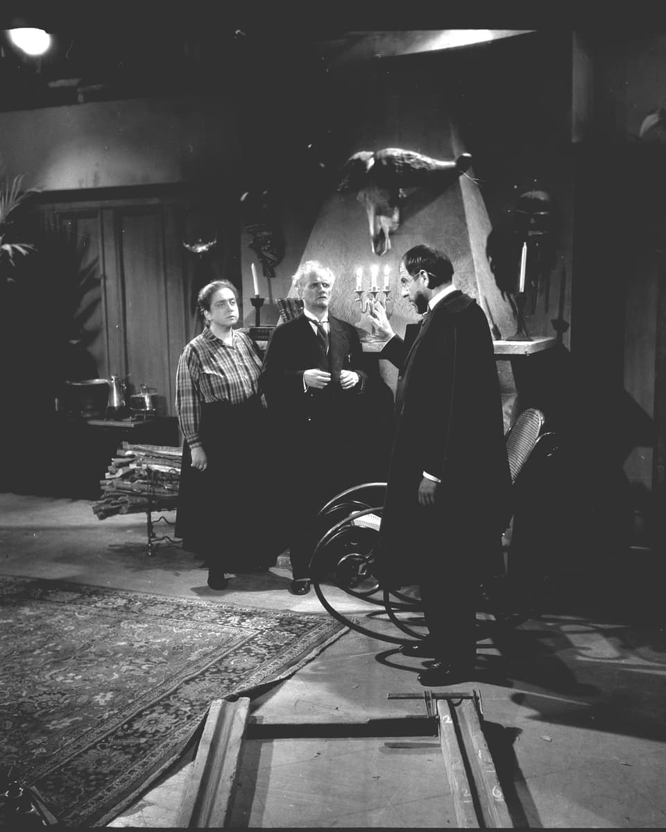 Drei Schauspieler (zwei Männer und eine Frau) im Geisterhaus aus Sicht der Kamera mit Dollyschienen am Boden.