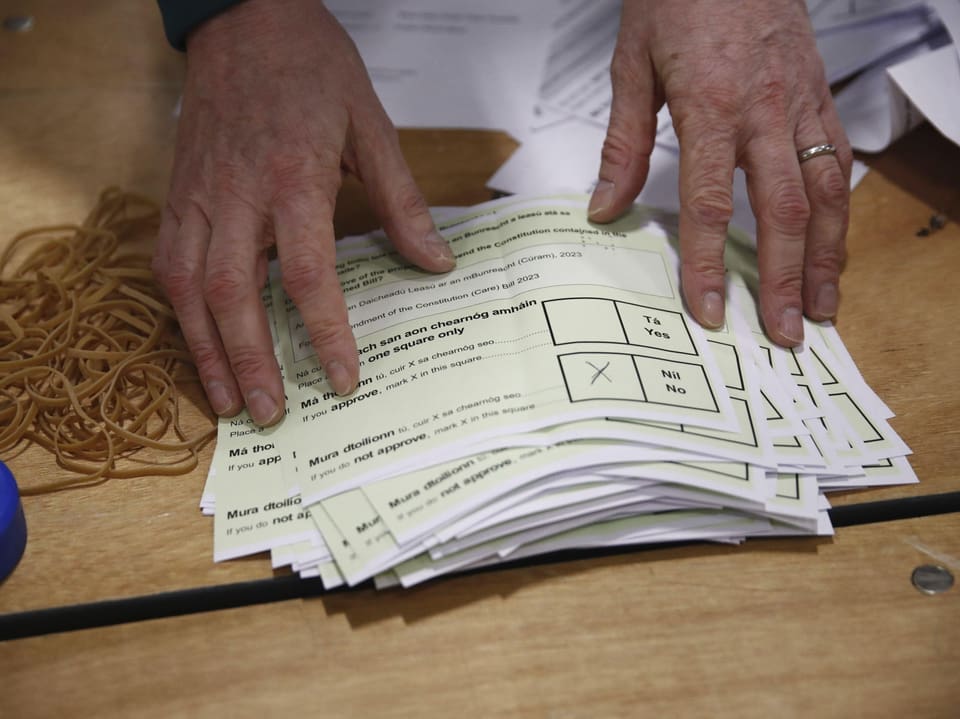 Zwei Hände ordnen einen Stapel mit Stimmzetteln.