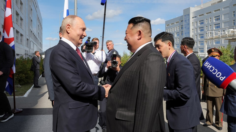Wladimir Putin und Kim-Jong-Un begrüssen sich lächelnd und schütteln die Hände