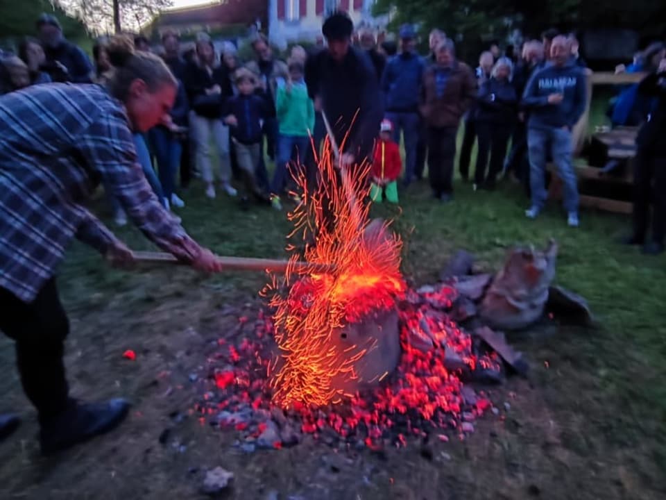 Mann mit Beil vor Feuer.