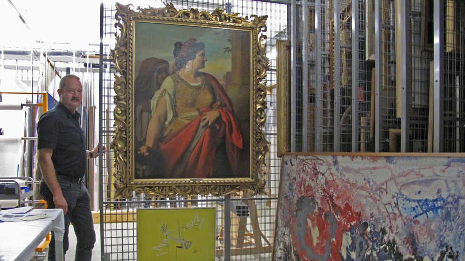 Heinz Stahlhut mit einem Gemälde im Archiv des Kunstmuseums.