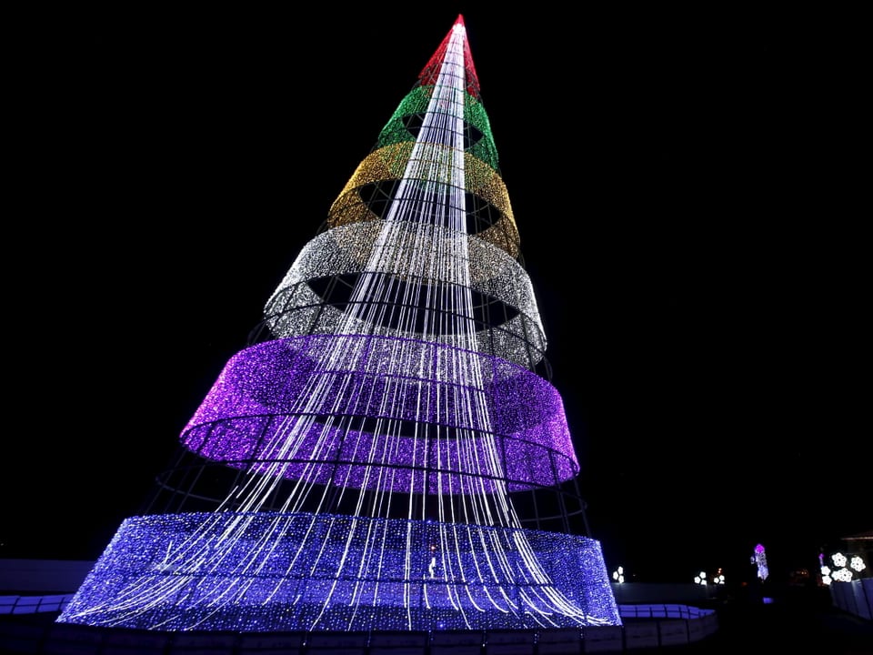 Farbige Lichtergirlanden zu einem Weihnachtsbaum angedordnet leuchten in der Nacht von Bogota