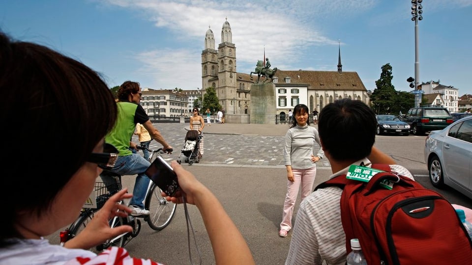 Touristen aus Asien posieren vor dem Denkmal von Hans Waldmann in Zürich