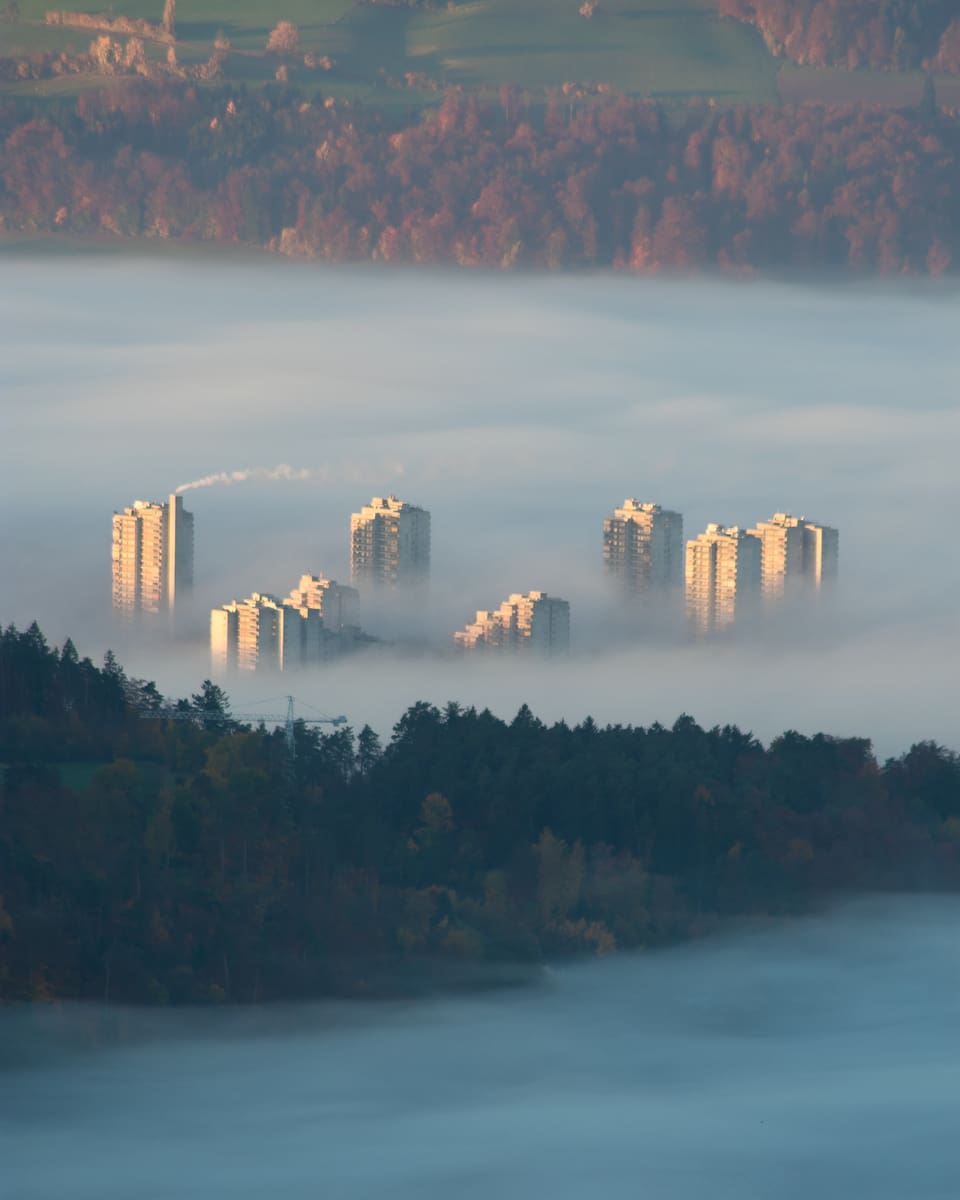Hochhäuser schauen aus dem Nebel.