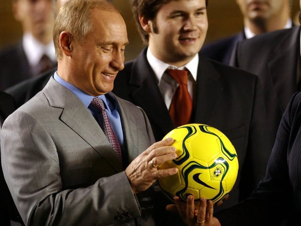 Putin erhält einen gelben Fussball.