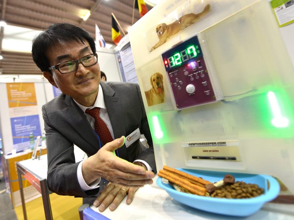 Ein Südkoreaner präsentiert einen neuen Futterautomaten für Haustiere.