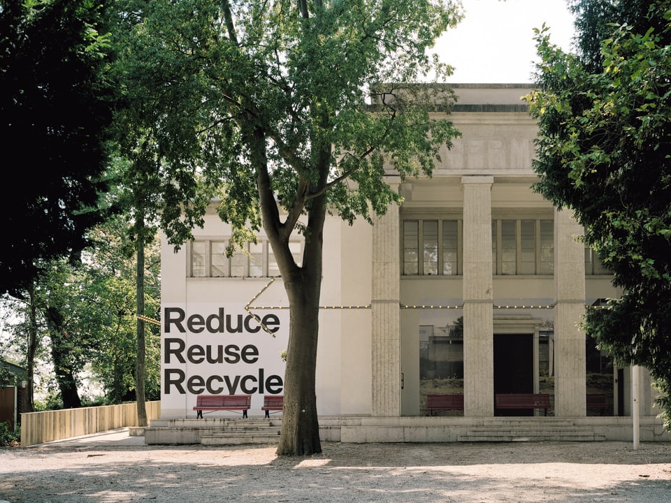 Der Deutsche Pavillon an der Biennale. Vor ihm ist ein Baum. An der Wand des Pavillons steht «Reduce, reuse, recycle»