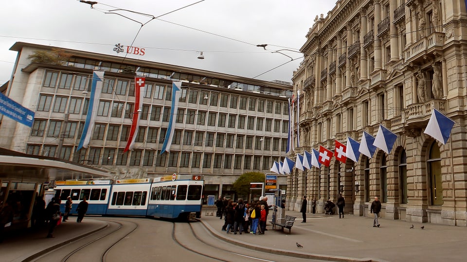 Paradeplatz in Zürich, Fassaden von UBS und CS und Tramhaltestelle davor.