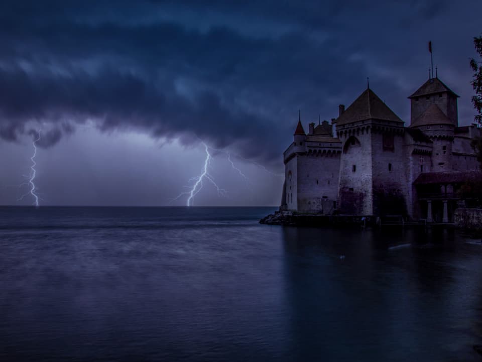 Dicke Wolkenl liegen über dem Schloss. Zwei Blitze entladen sich im Hintergrund des Bildes.