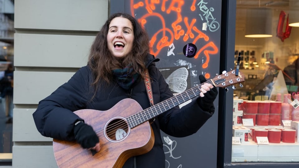 Ginn Loon singt und spielt die Gitarre in der Bieler Innenstadt.