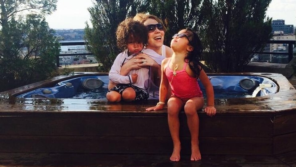 Mariah Carey mit ihren Zwillingen Moroccan und Monroe an einem kleinen Pool sitzend.