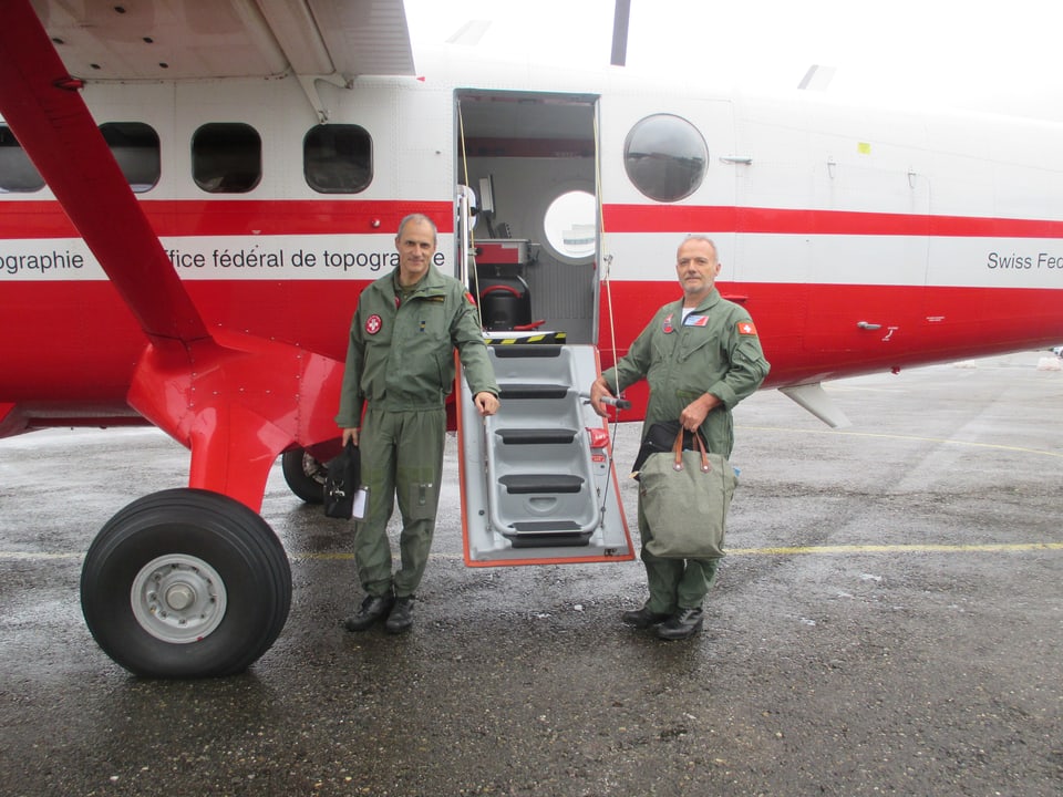 Zwei Männer in Fluguniform vor einem rot-weissen Flugzeug