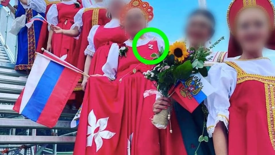 Eine Frau trägt eine rote Tracht mit einem «Z» dran.