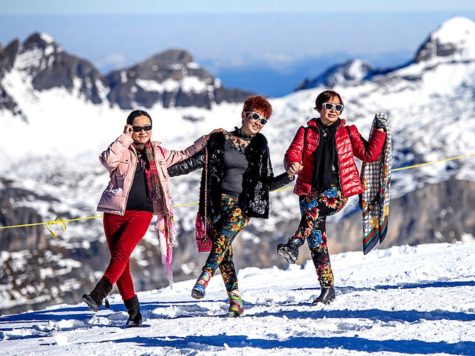 Drei chinesische Touristinnen posieren auf dem Jungfraujoch für ein Foto