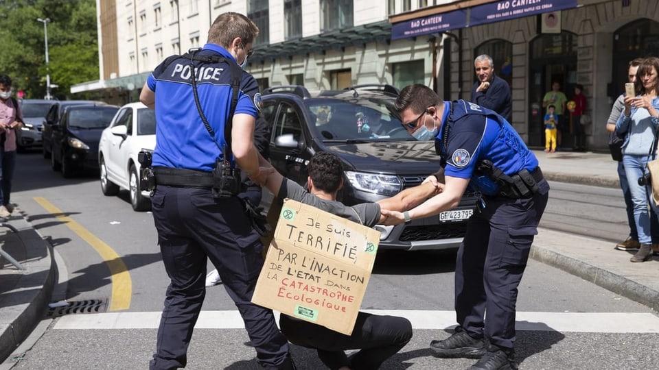 Ein Aktivist von Extinction Rebellion (XR) wird von der Genfer Polizei von der Strasse entfernt.