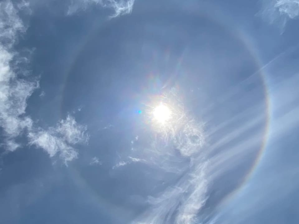 Regenbogen-Ring um die Sonne am milchigen Himmel