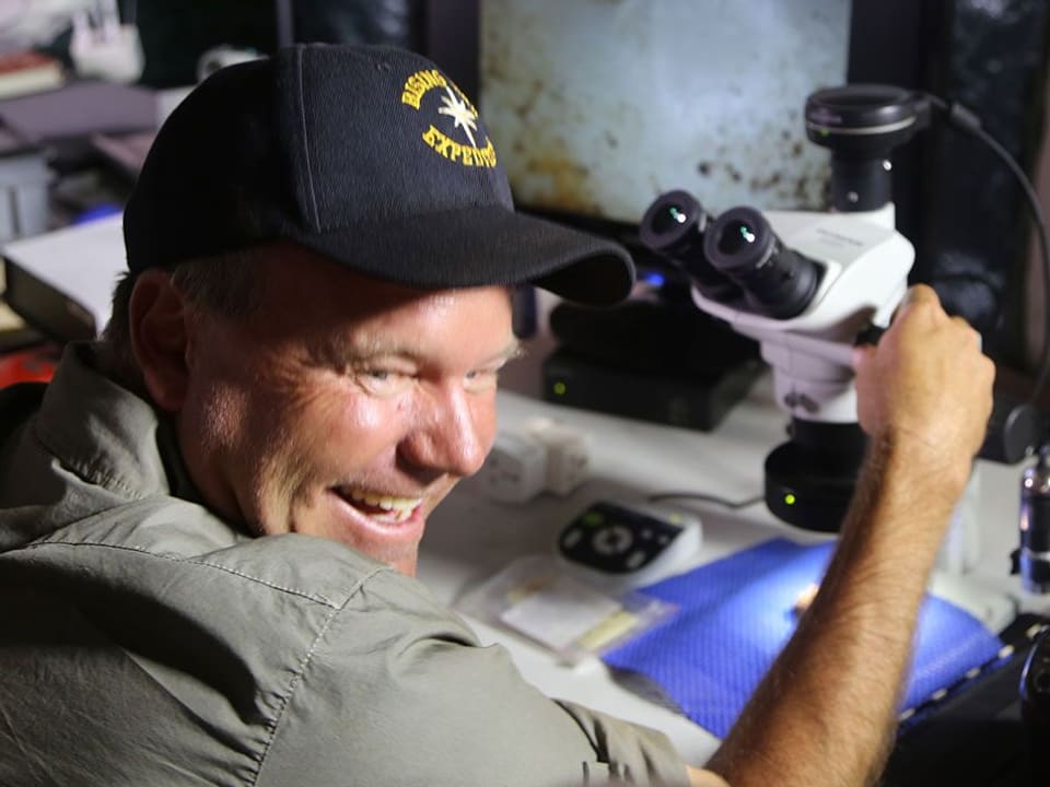 Lee Berger vor einem Mikroskop