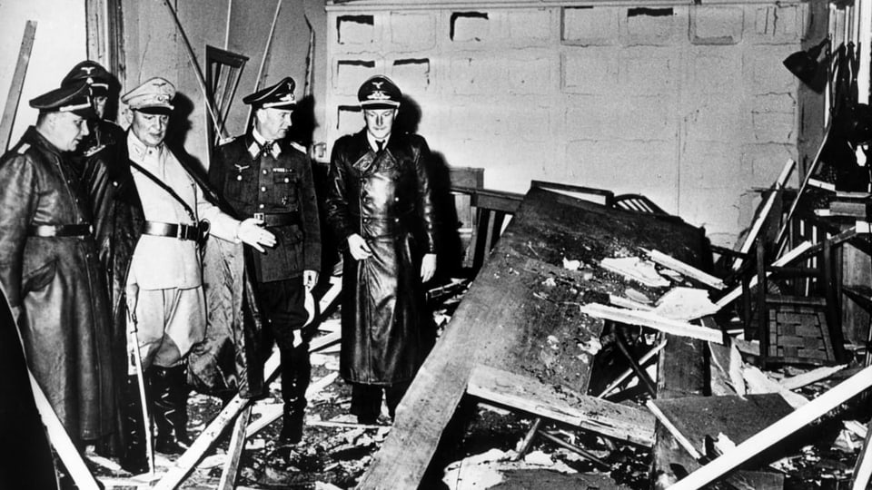 Schwarz-weisses dokumentarisches Foto: NS-Soldaten vor den Trümmern eines Tisches. 
