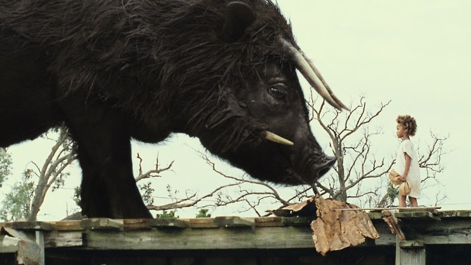 Die sechsjährige Hauptfigur Hushpuppy, steht vor einem riesigen Büffel.