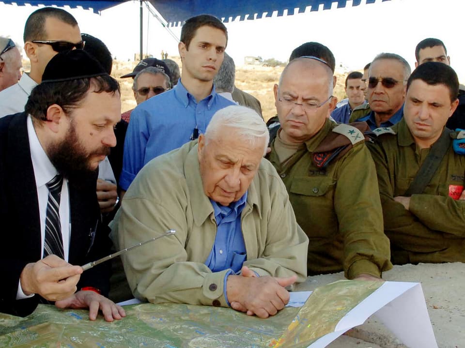 Ariel Sharon lässt sich von Militäroffizieren und einem Architekten Pläne der Region erklären.