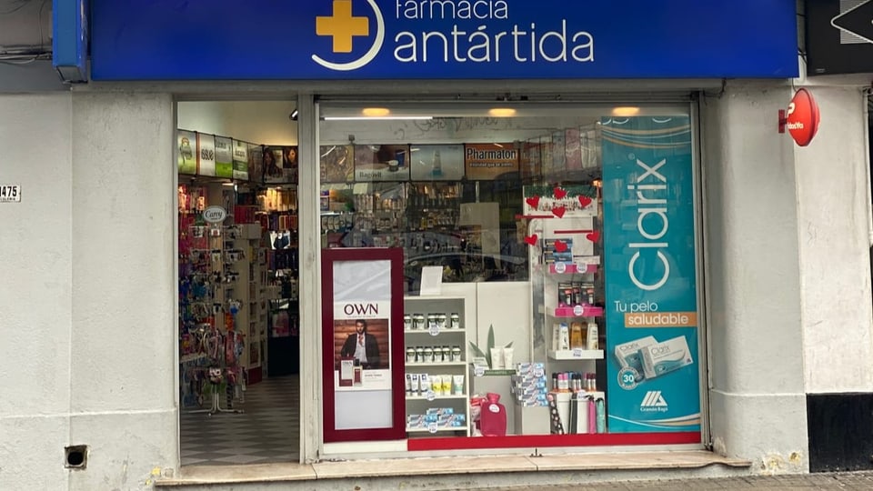 Eine Apotheke mit offener Tür von vorne fotografiert.