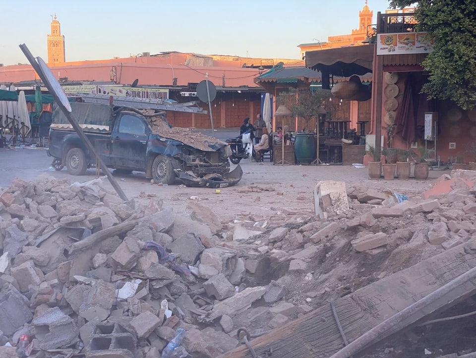 Trümmer und ein zerstörtes Auto liegen auf einer Strasse in Marrakesch.