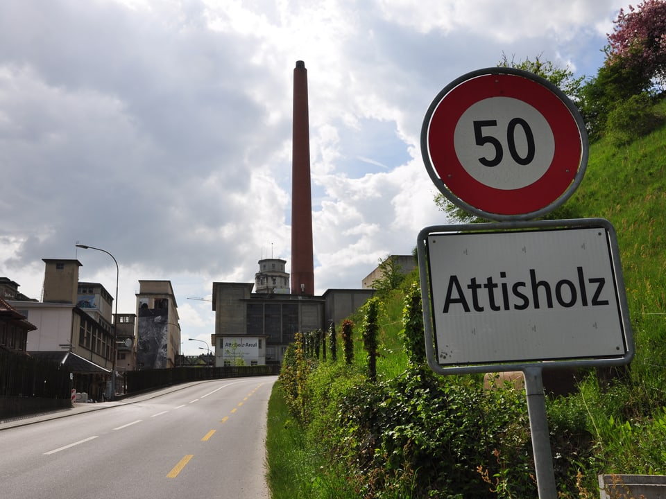 Ortsschild Attisholz. Im Hintergrund Fabrikareal.