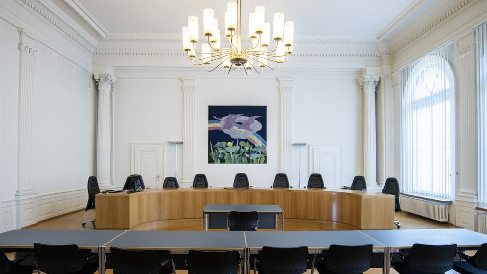 Ein leerer Gerichtssaal in einem stattlichen Gebäude mit sehr vielen Stühlen