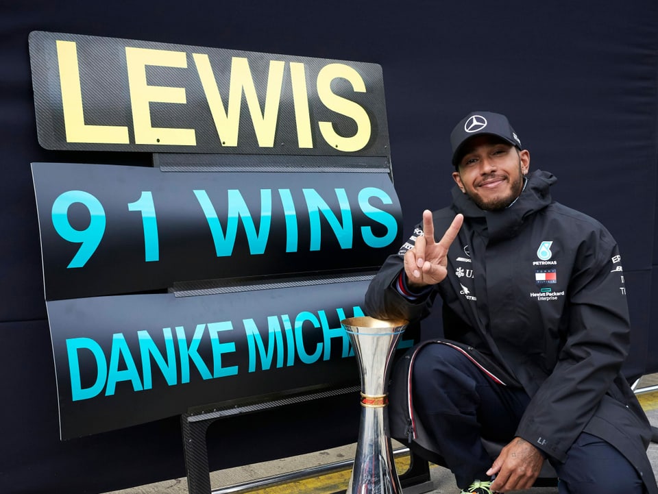 Lewis Hamilton posiert mit dem Siegerpokal