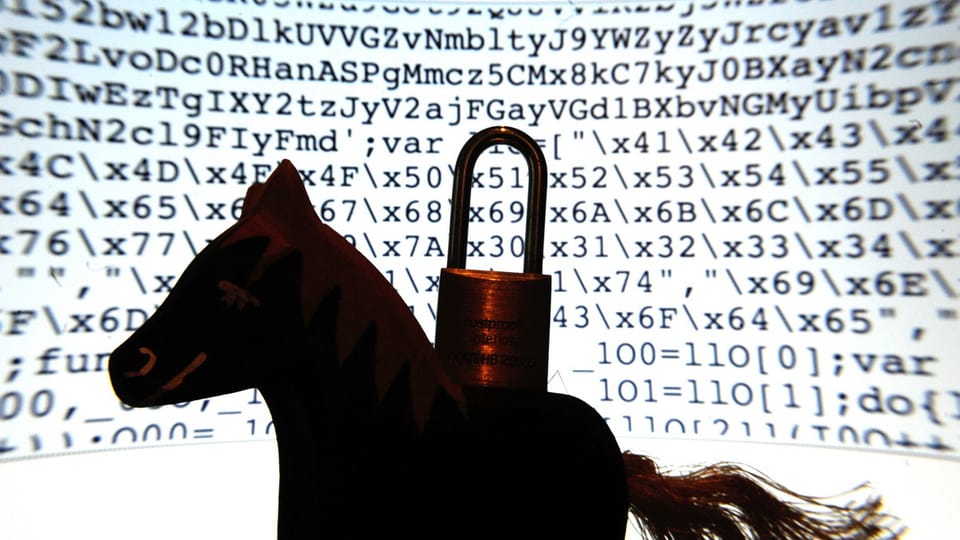 Ein Spielzeugpferd mit einem Vorhängeschloss auf dem Rücken vor einem Bildschirm voller Codes.