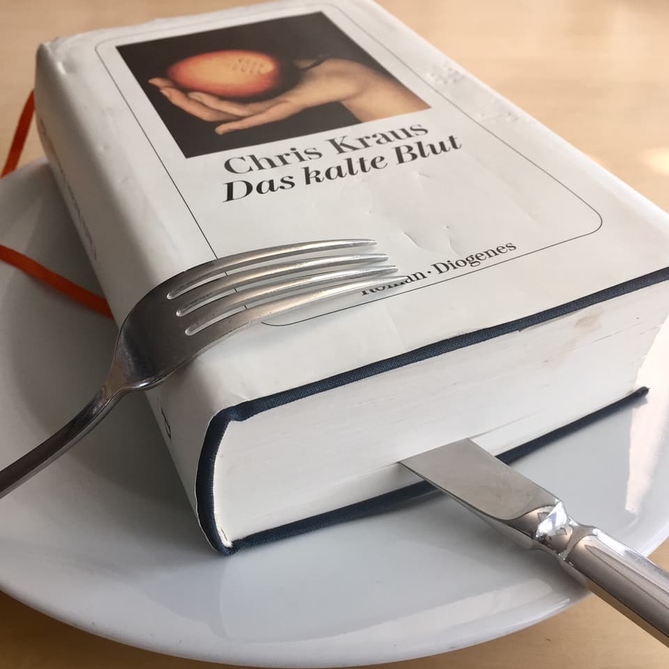 «Das kalte Buch» von Chris Kraus liegt auf einem Teller. Das Messer steckt im Buch.