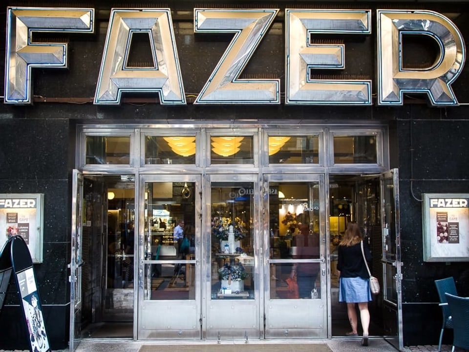 Eine junge Frau geht ins Café FAZER.