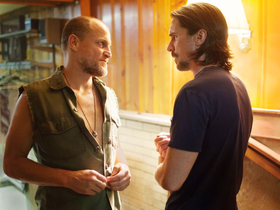 Woody Harrelson und Christian Bale stehen sich gegenüber.