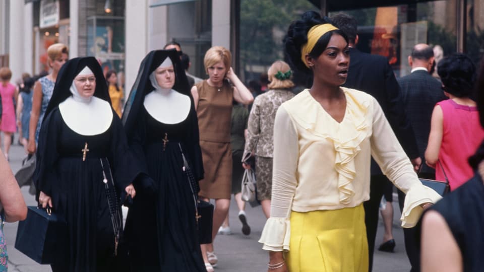 Zwei Nonnen und eine Frau in einem gelben Gewand