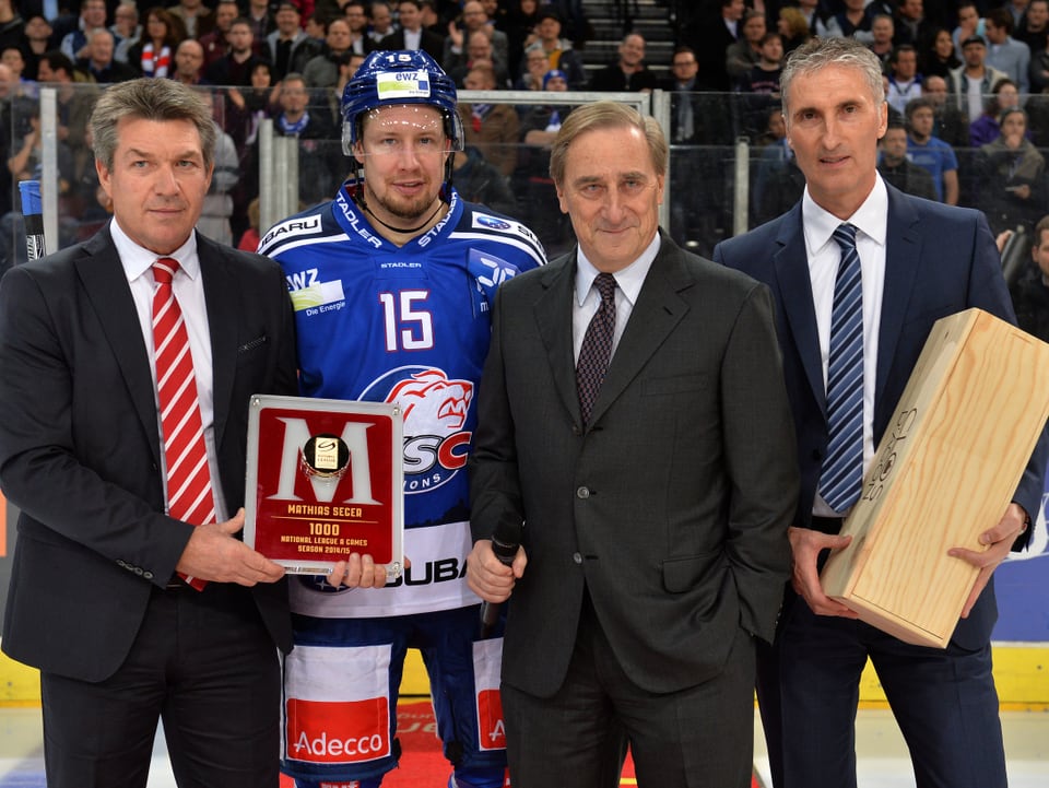Mathias Seger wird anlässlich seines 1000. NLA-Spiels im Hallenstadion geehrt. Er erhält eine Auszeichnung und eine Flasche Wein in einer Holz-Box.