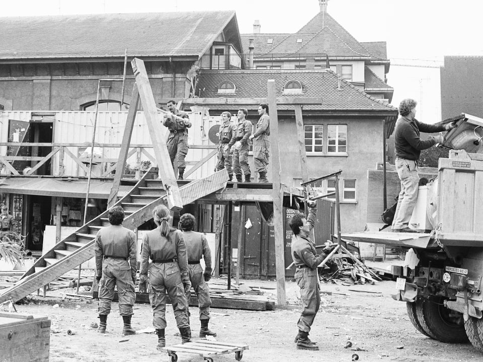 Schwarzweissbild: ein halbes Dutzend Polizisten räumen die Alte Stadtgärtnerei, im Vordergrund ein Holzgestell.