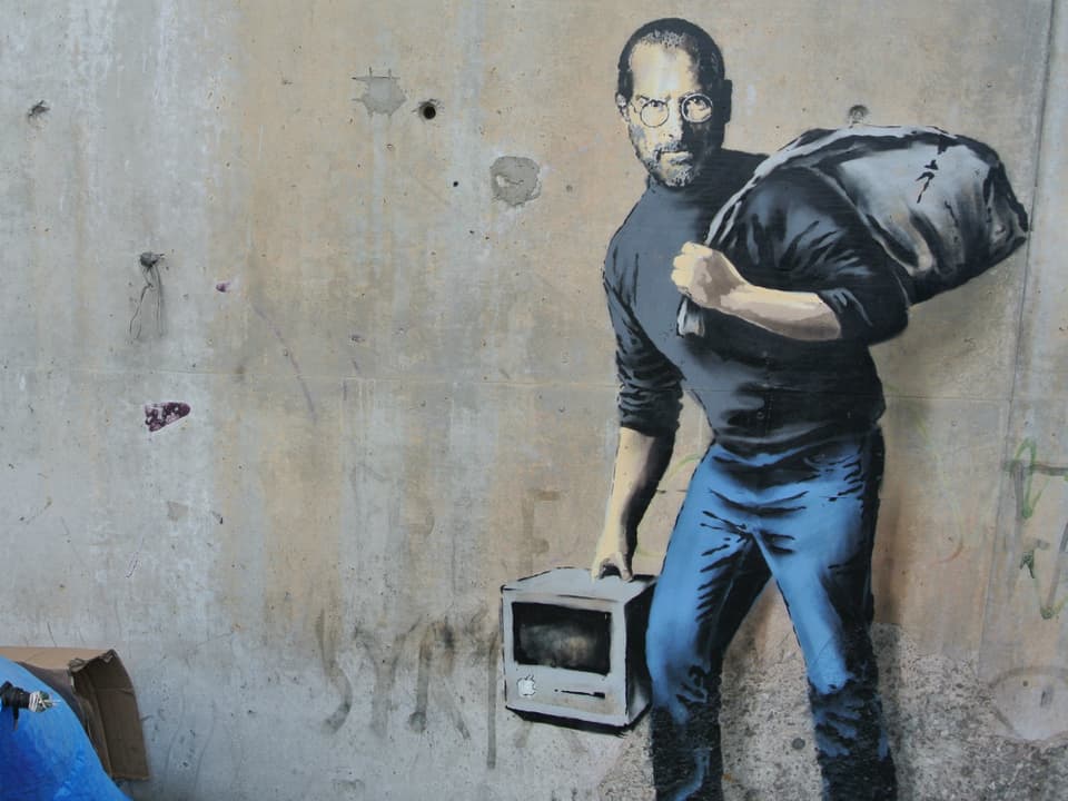 Ein Apple-Rechner in der Hand, ein Müllbeutel auf dem Rücken. Steve Jobs. 