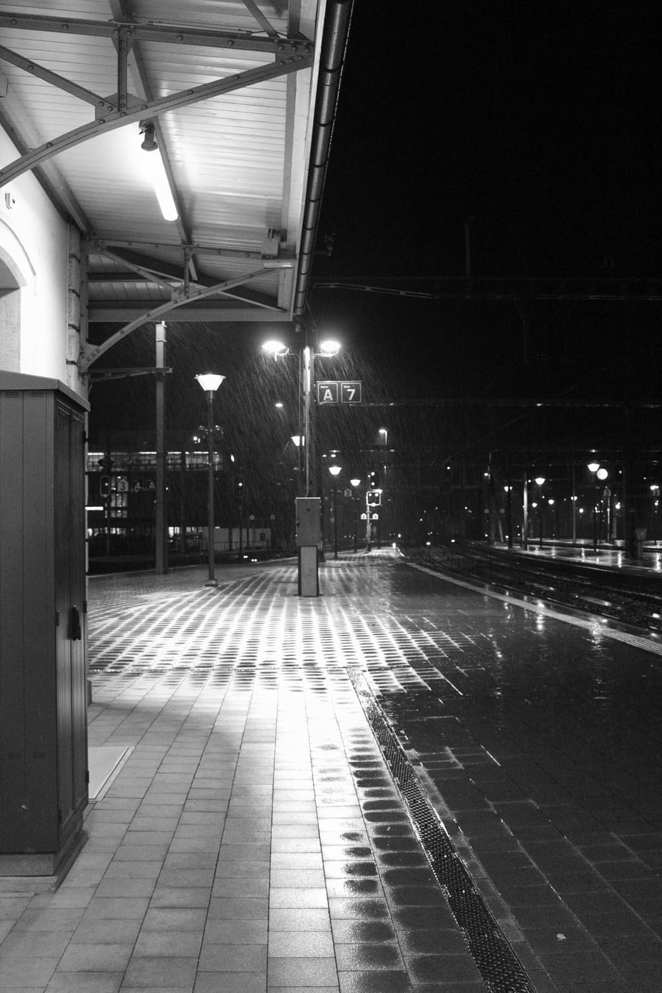 Verregneter Bahnsteig in schwarzweiss.