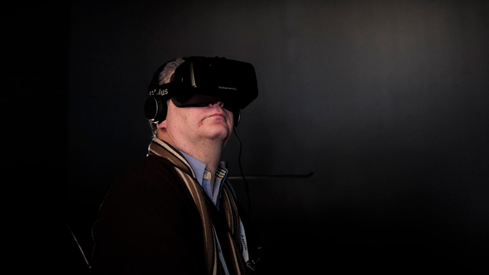 Ein Mann trägt ein Oculus Brille in einem dunklen Raum.
