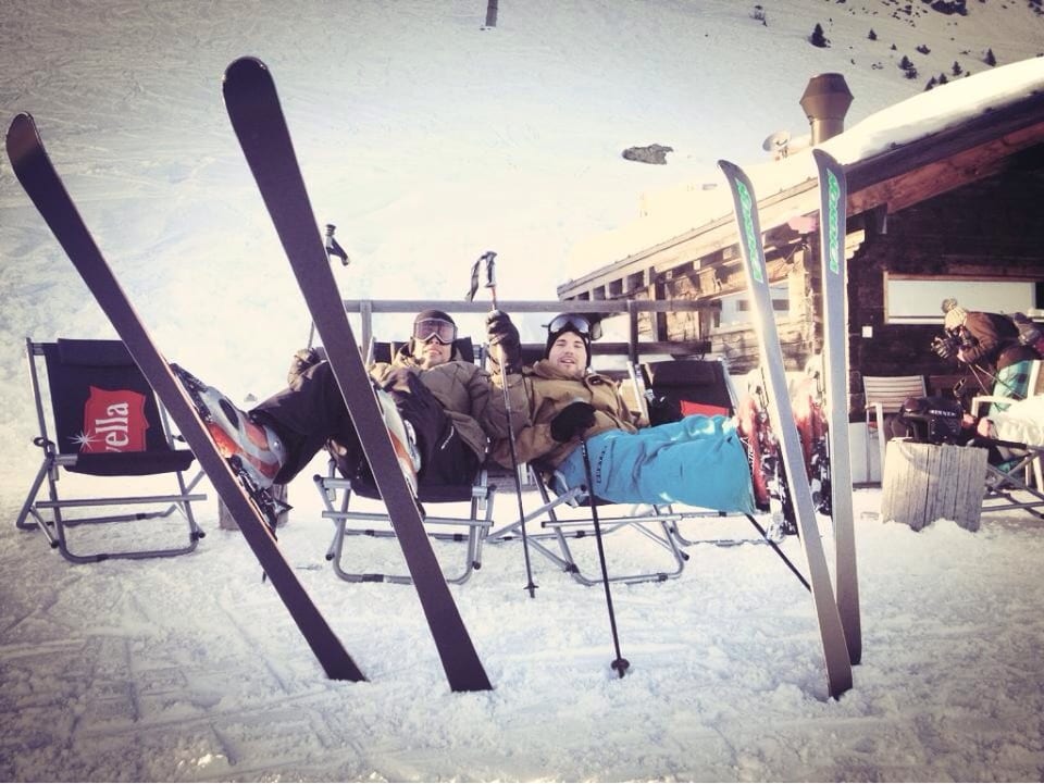 Zwei Männer mit Skiern im Liegestuhl.