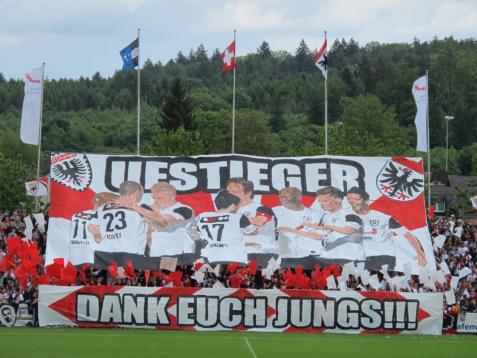Fans feiern mit einem Plaket den Aufstieg des FC Aarau