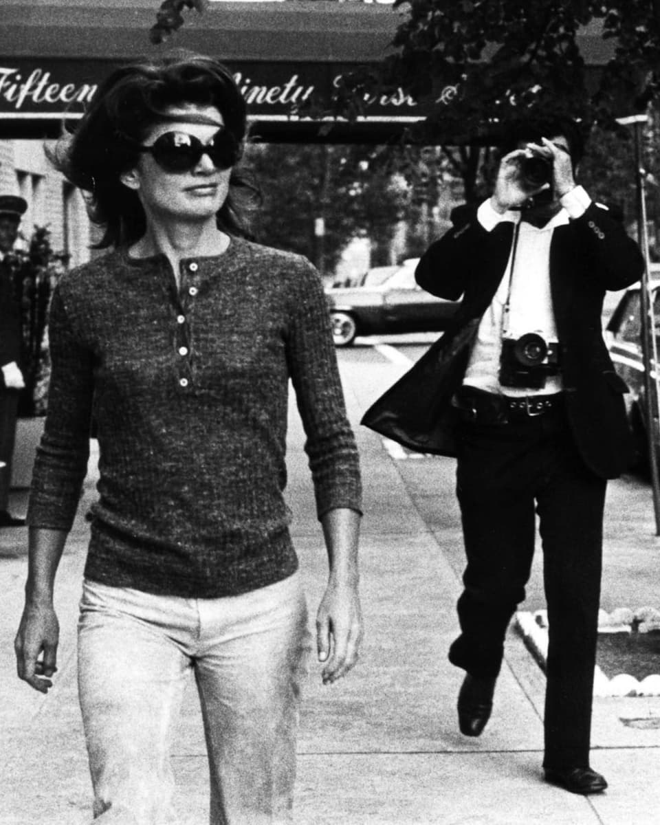 Jackie Onassis wird von einem Fotografen fotografiert.