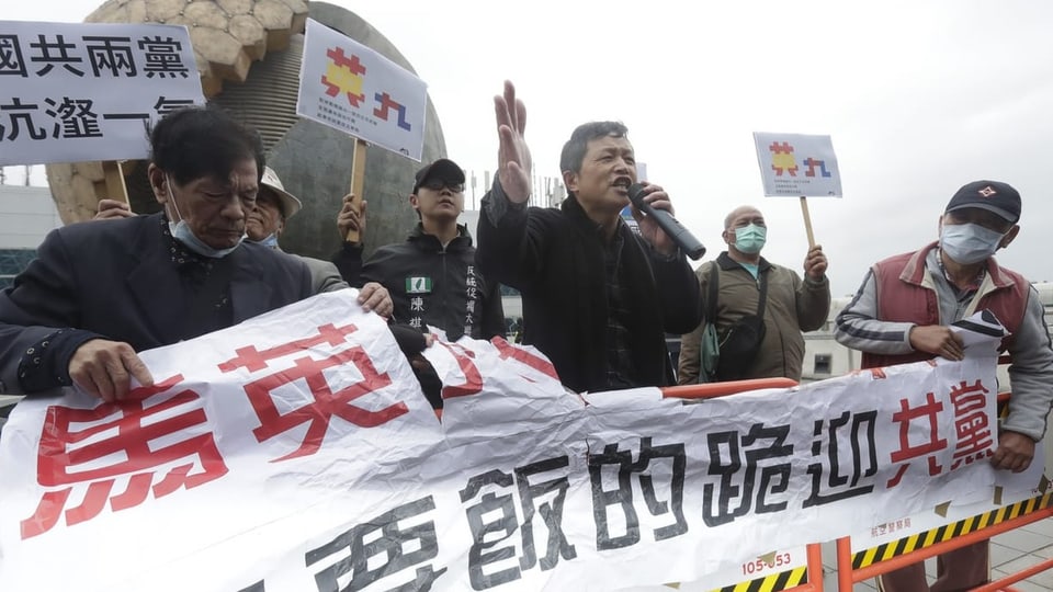 Demonstrierende Taiwaner mit Transparent.
