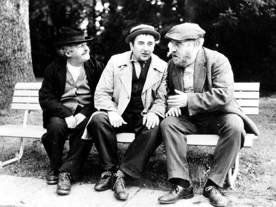 Drei Männer sitzen auf einer Bank.