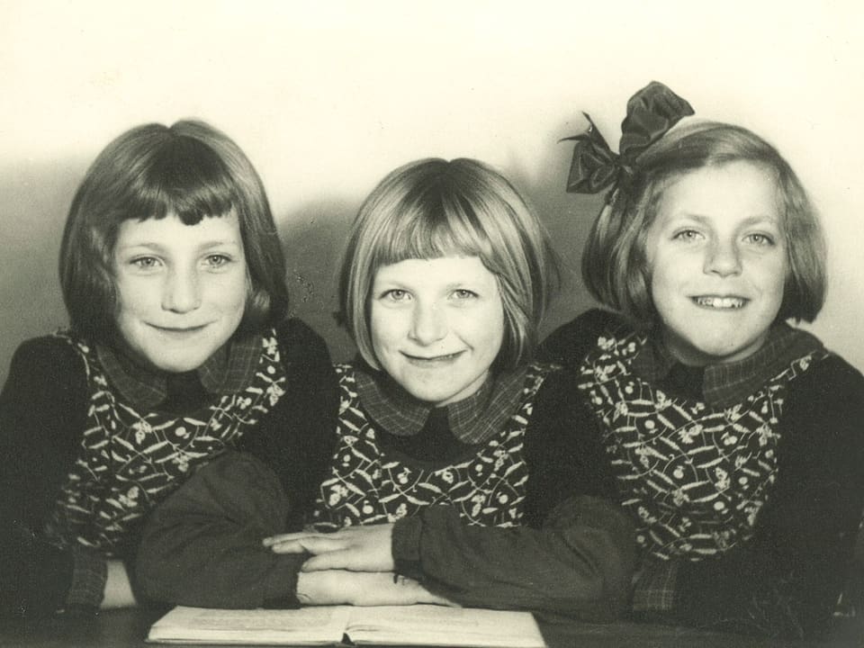Schwarz-Weiss-Fotografie mit drei Mädchen, die alle gleiche Röcke tragen.