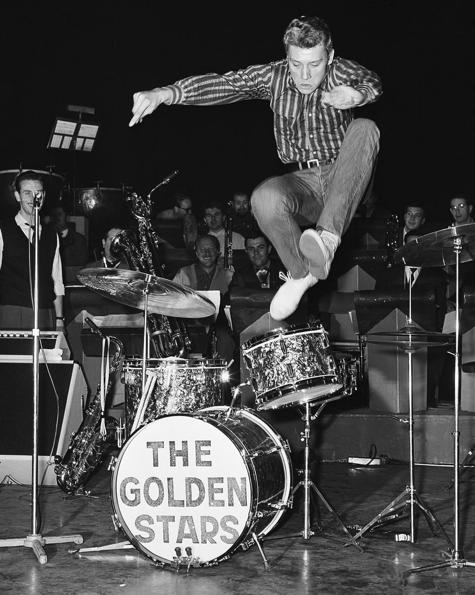 Der 21jährige Johnny Halliday springt im Oktober 1962 bei einem Konzert in Paris schwungvoll über das Schlagzeug.