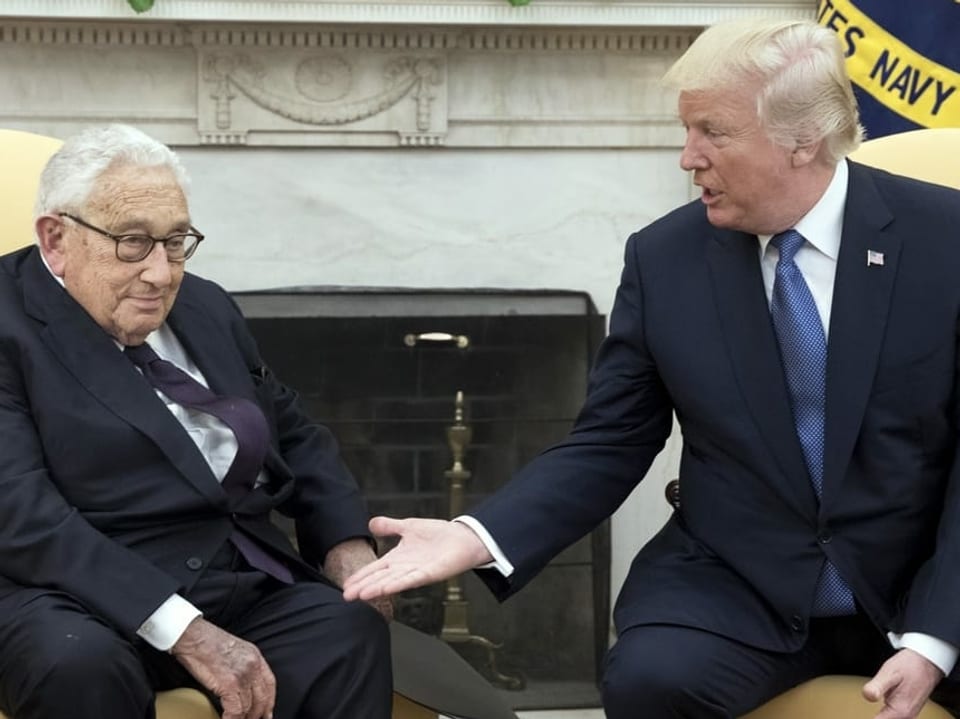 Henry Kissinger sitzt links neben Donald Trump.