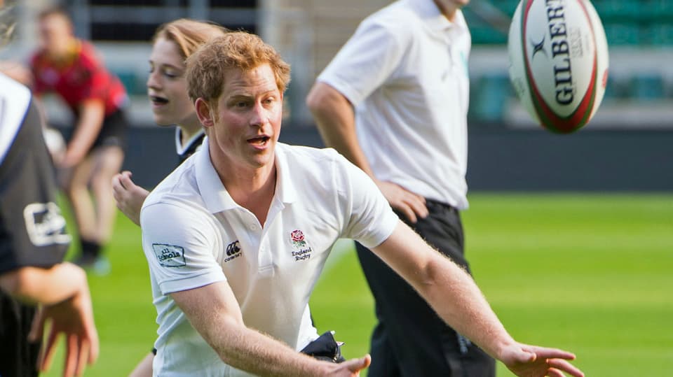 Prinz Harry fängt einen Rugbyball.