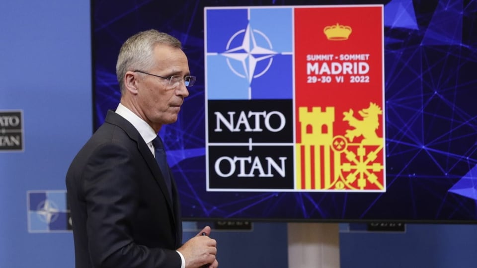 Nato-Generalsekretär Jens Stoltenberg steht vor einem Nato- und Nato-Gipfel-Logo.