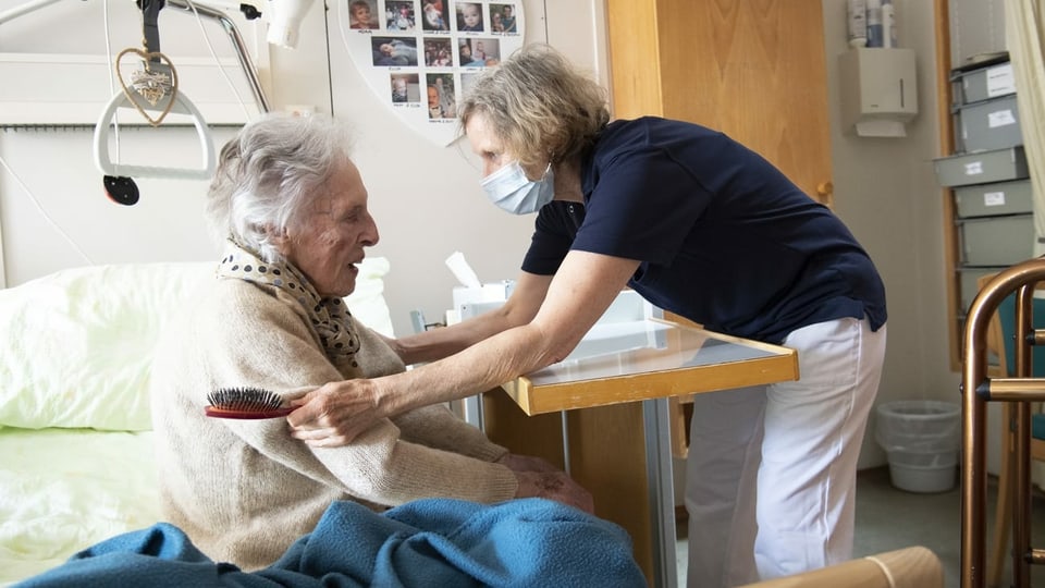 Pflegefachfrau betreut eine alte Frau